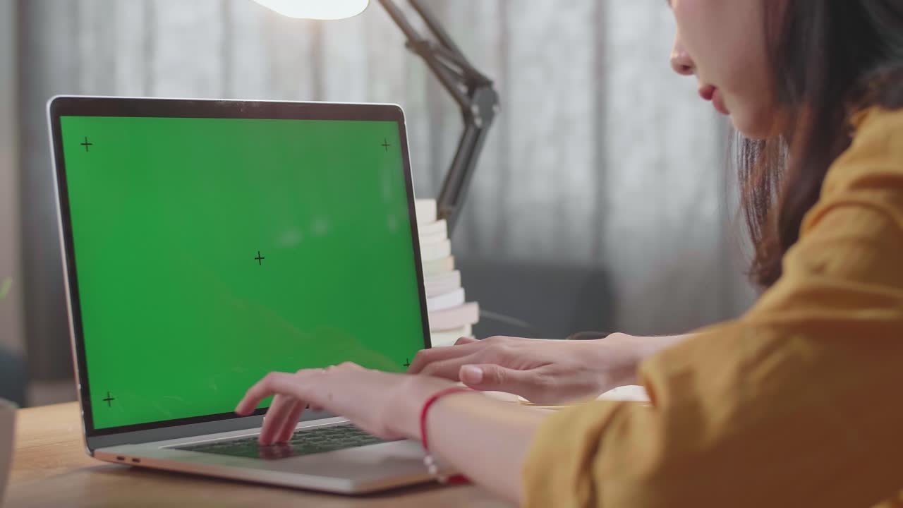 mujer trabajando en una computadora portátil con una pantalla verde