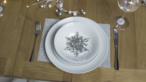 mesa de cena navideña con plato - copo de nieve plateado