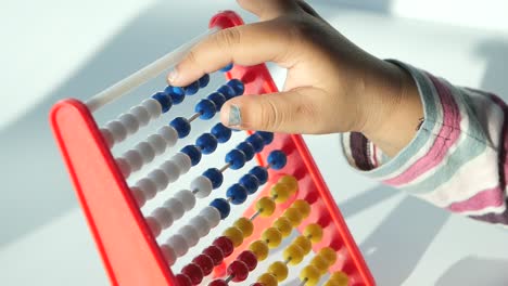 Cropped-view-of-child-hand-with-abacus-closeup