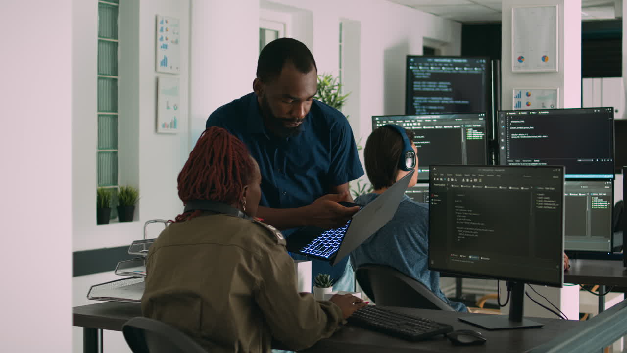 Two software coders analyzing source code looking for errors on laptop