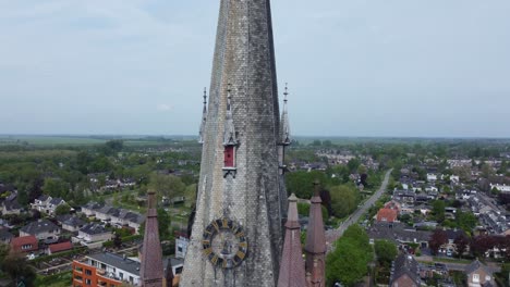 rising aerial crane shot of church tower, small town in the netherlands