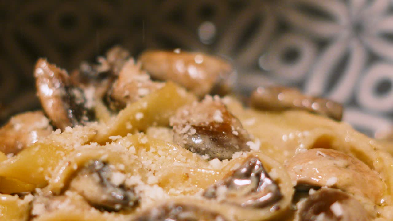 Parmesan Italian Cheese Being Sprinkled in Slow Motion on Creamy Tagliatelle Mushroom Pasta Dish Ready to Serve to Family or Customer in Restaurant 4K