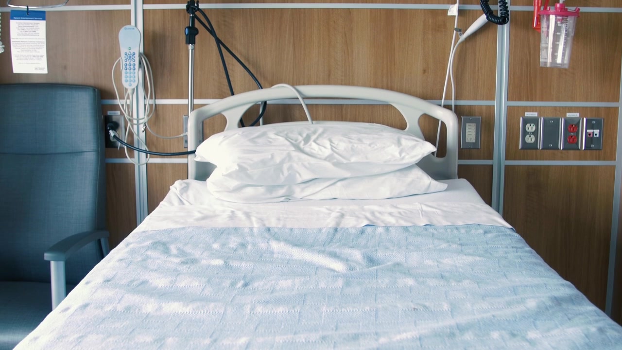 Inclinando hacia arriba en una cama de hospital vacía con sábanas y almohadas limpias en una habitación de hospital vacía.