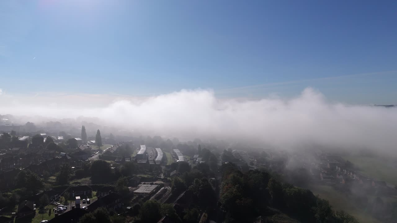Suburban landscape covered by thick morning mist and fog, Small town of Dewsbury and Heckmondwike. Cold winter Yorkshire morning. Cityscape with homes rooftops and busy roads. Winter scene