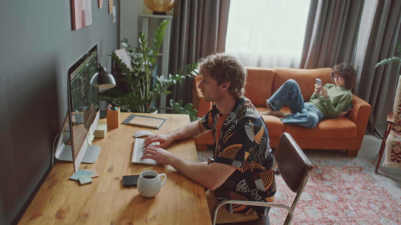 Programmer Working Remotely on Desktop Computer at Home