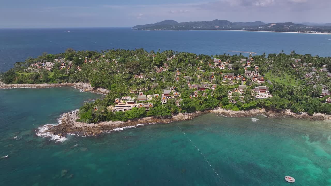 Luxury resort with huts and tropical vegetation on peninsula in Phuket, Thailand. Drone