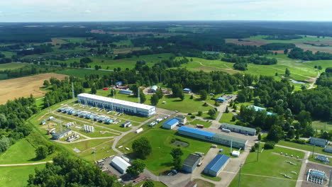 aerial tracking shot overlooking a natural gas pumping station on the countryside