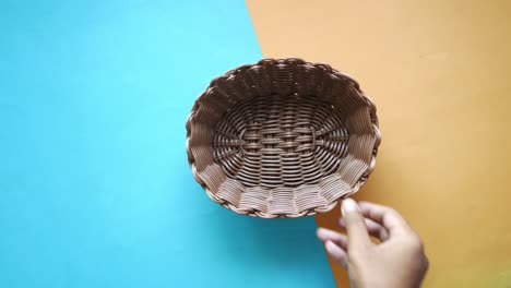 mano con una canasta de mimbre marrón