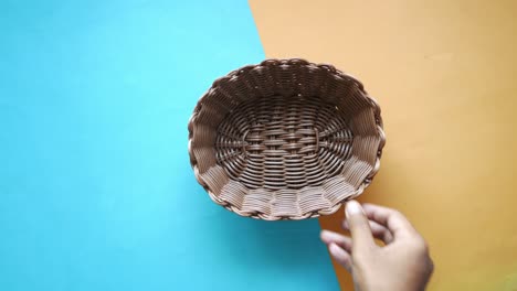 hand holding a brown wicker basket