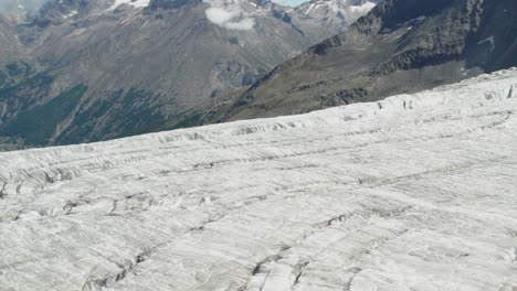 close areial fly over ice glacier with deep crevasses and cracks, glacier melting concept of global warming, aerial fly over of allalingletscher switzerland