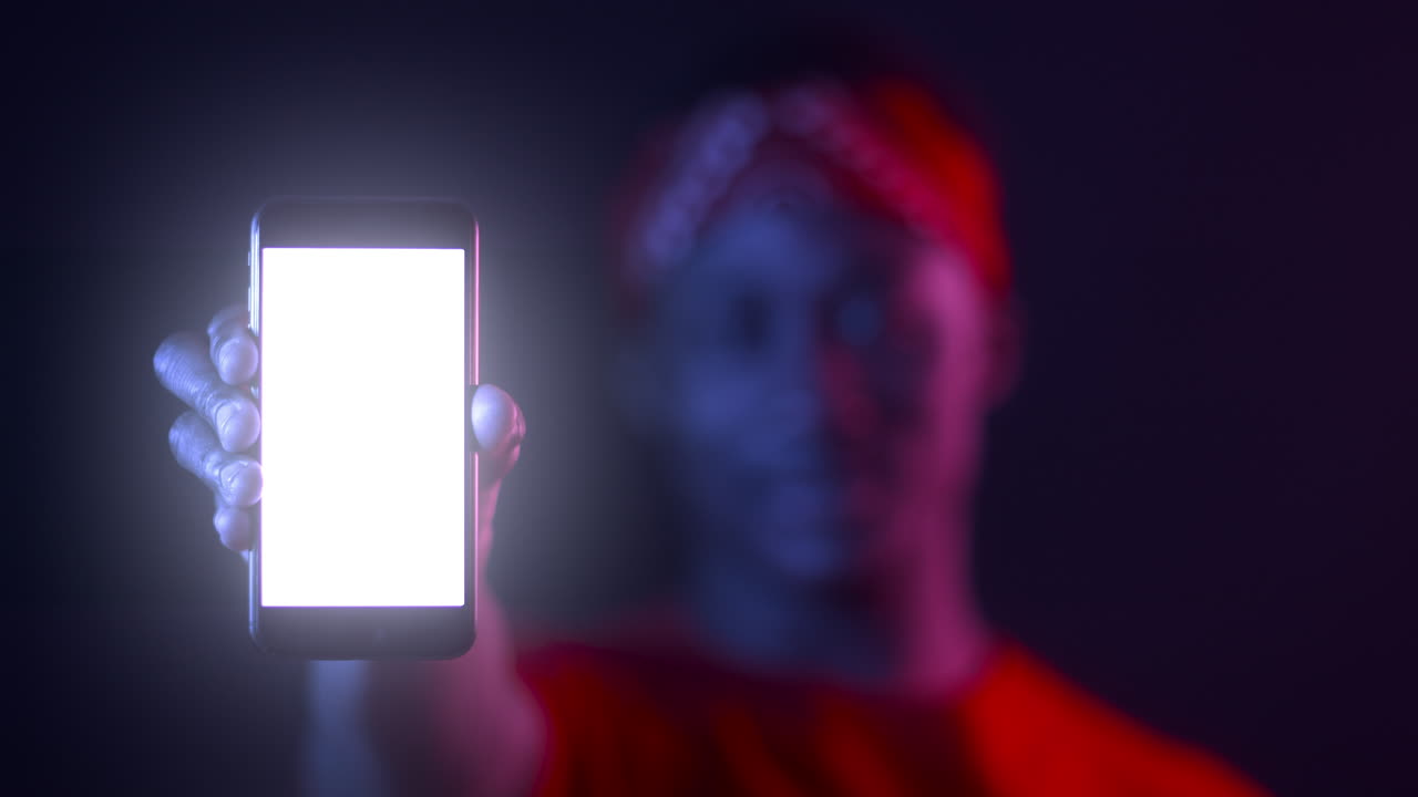 persona que sostiene un teléfono inteligente con pantalla en blanco