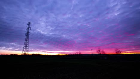 Zeitraffer-Von-Strommasten-Auf-Einem-Bewölkten-Rotvioletten-Sonnenuntergang