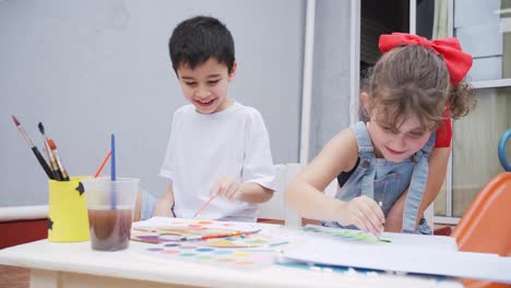 cheerful children painting at table