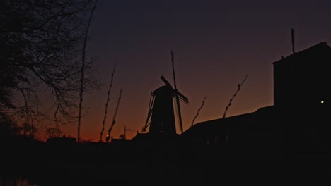 stunning time lapse of a beautiful dutch landscape with a classic windmill at sunrise - zoom in