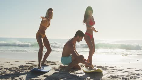 caucasian friends training surf styling on the sand