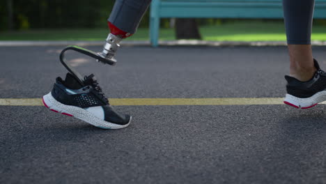 jogger with artificial limb exercising on running surface. girl doing cardio