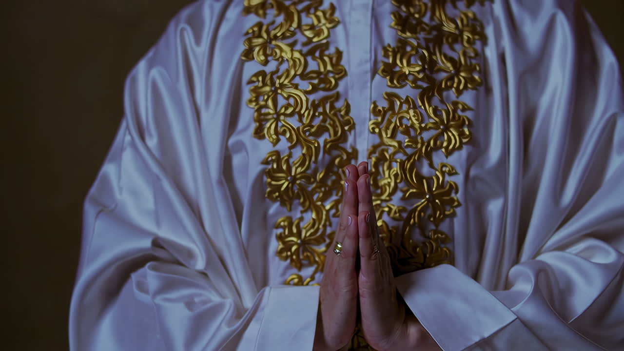 Person Praying in Prayer Position with Traditional Islamic Clothing