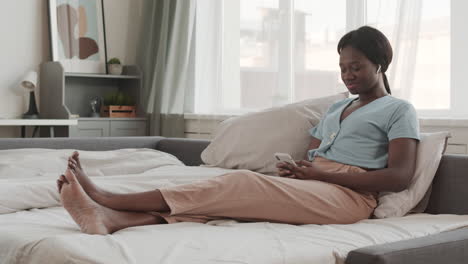 young african-american woman enjoying music in bed
