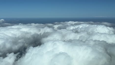 sobrevolando algunas nubes esponjosas durante el crucero, disparado desde una cabina de avión a 5000 m de altura