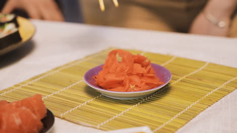 Nahaufnahme-Einer-Japanerin,-Die-Essstäbchen-Hält-Und-Wasabi-Pflückt,-Während-Sie-In-Der-Küche-Liegt