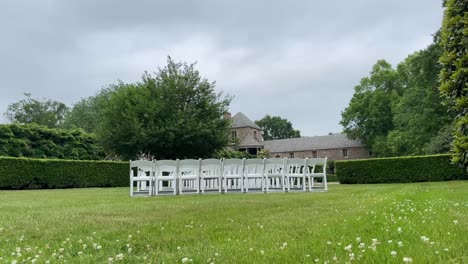 showing off this grassy path with hedges and a building in background