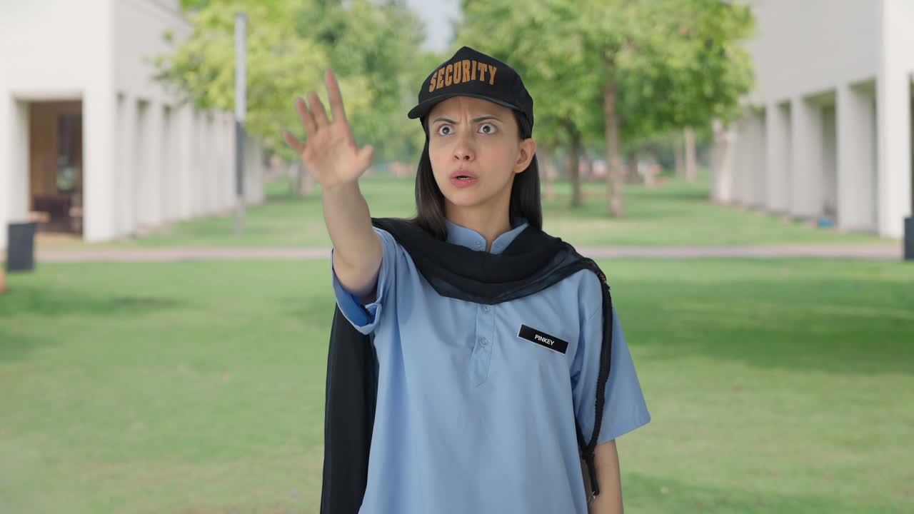 좌절 된 인도 여성 보안 경비원 이 휘파람 을 불어서 누군가 에게 전화 하고 있다