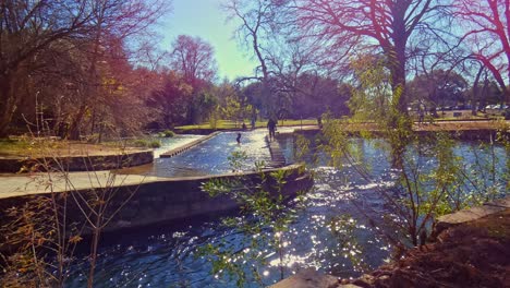 father spending time with his daughter splashing and playing in the park river