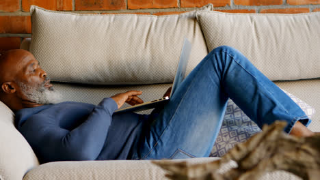 senior man using laptop in living room 4k