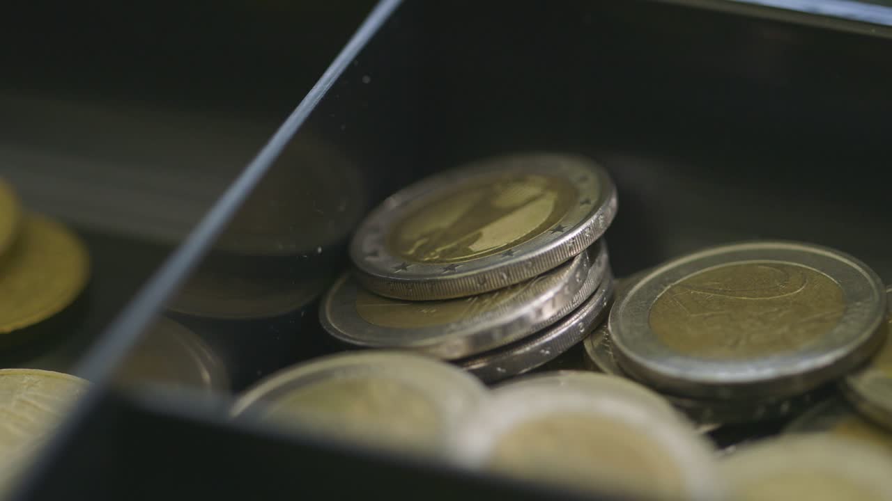 primer plano de las monedas de euro en un cajón que refleja una iluminación sutil