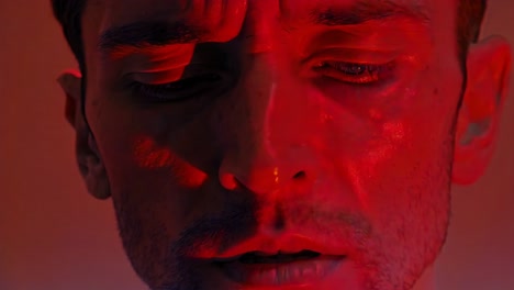 close-up portrait of a man with a stressed expression, illuminated by neon light