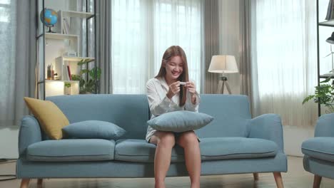 happy woman looking at a positive pregnancy test