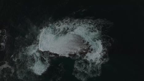 dramatic aerial of waves crashing against the rugged coastline of wollongong, new south wales, australia