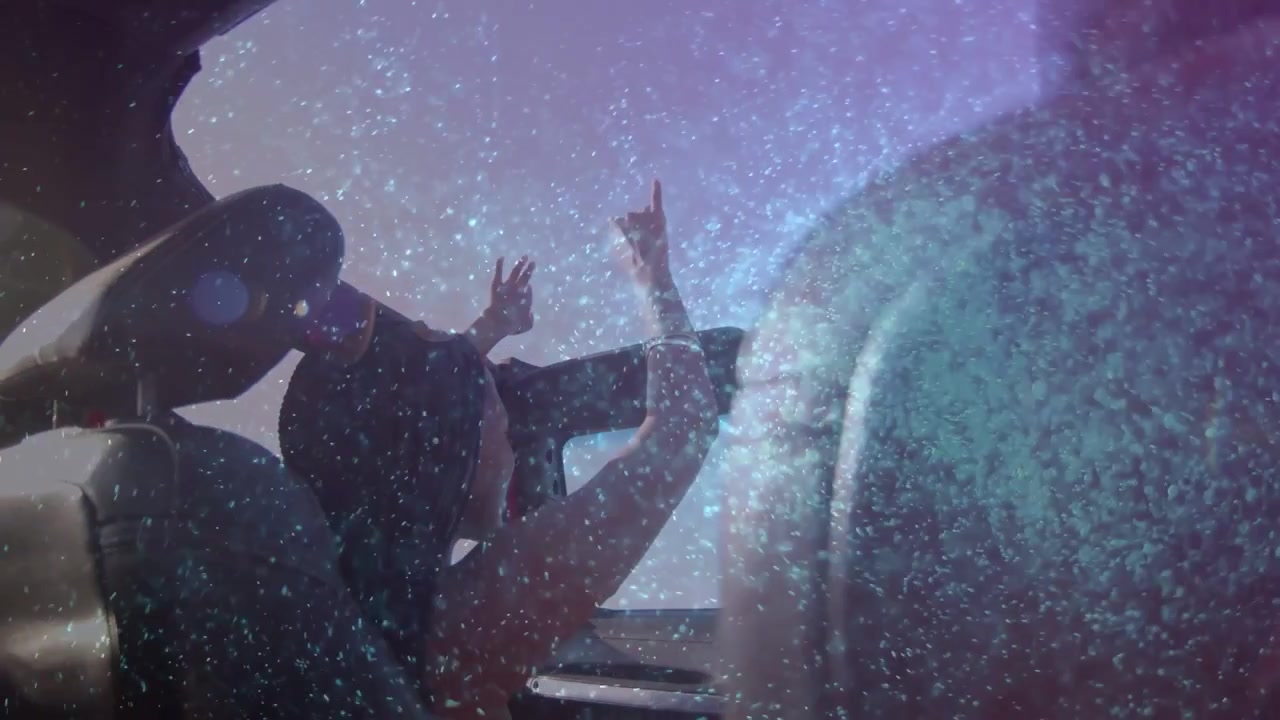 Passenger lifting arms in drop-top sparking starry overlay around arms, waving and lowering for ads