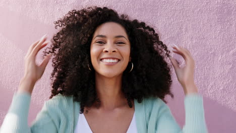 portrait of black woman touching her afro outdoor