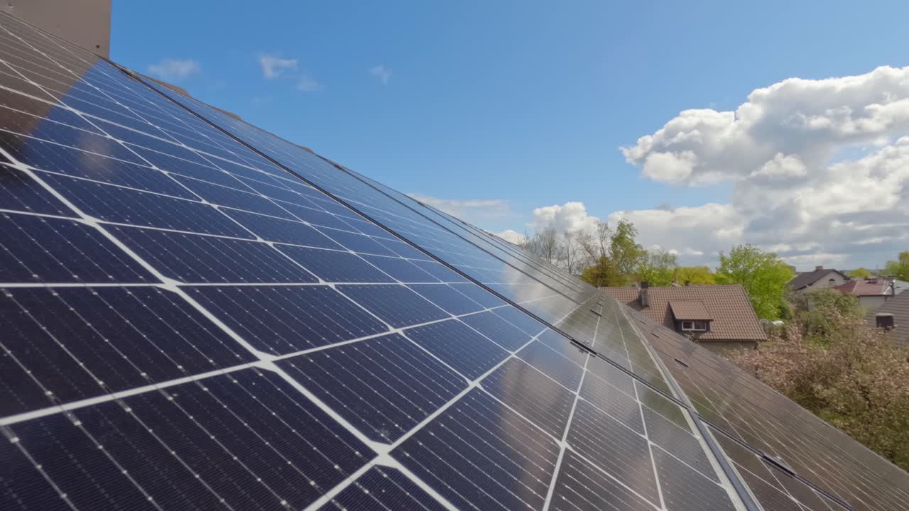 Solar panels on rooftop reflecting flowing clouds, time lapse view