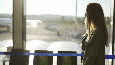 movimiento lento de un viajero elegante con máscara facial azul caminando por la terminal del aeropuerto