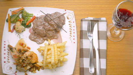 carne en salsa, gambas, verduras al vapor y patatas fritas, mediterranea