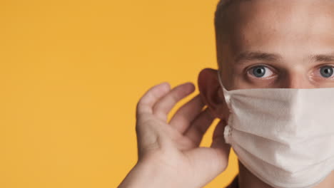 caucasian young guy putting face mask on