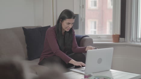 Young-Attractive-Woman-Throws-Her-Arms-In-The-Air-And-Celebrates-As-She-Completes-Online-Purchase---Ungraded