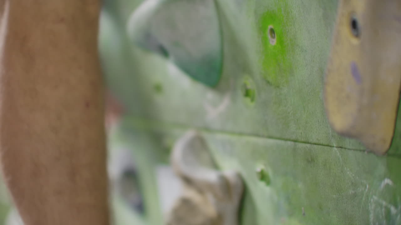 바위 등반을 위한 신발을 입은 발의 클로즈업으로 등반 벽에 있는 장애물을 극복합니다.