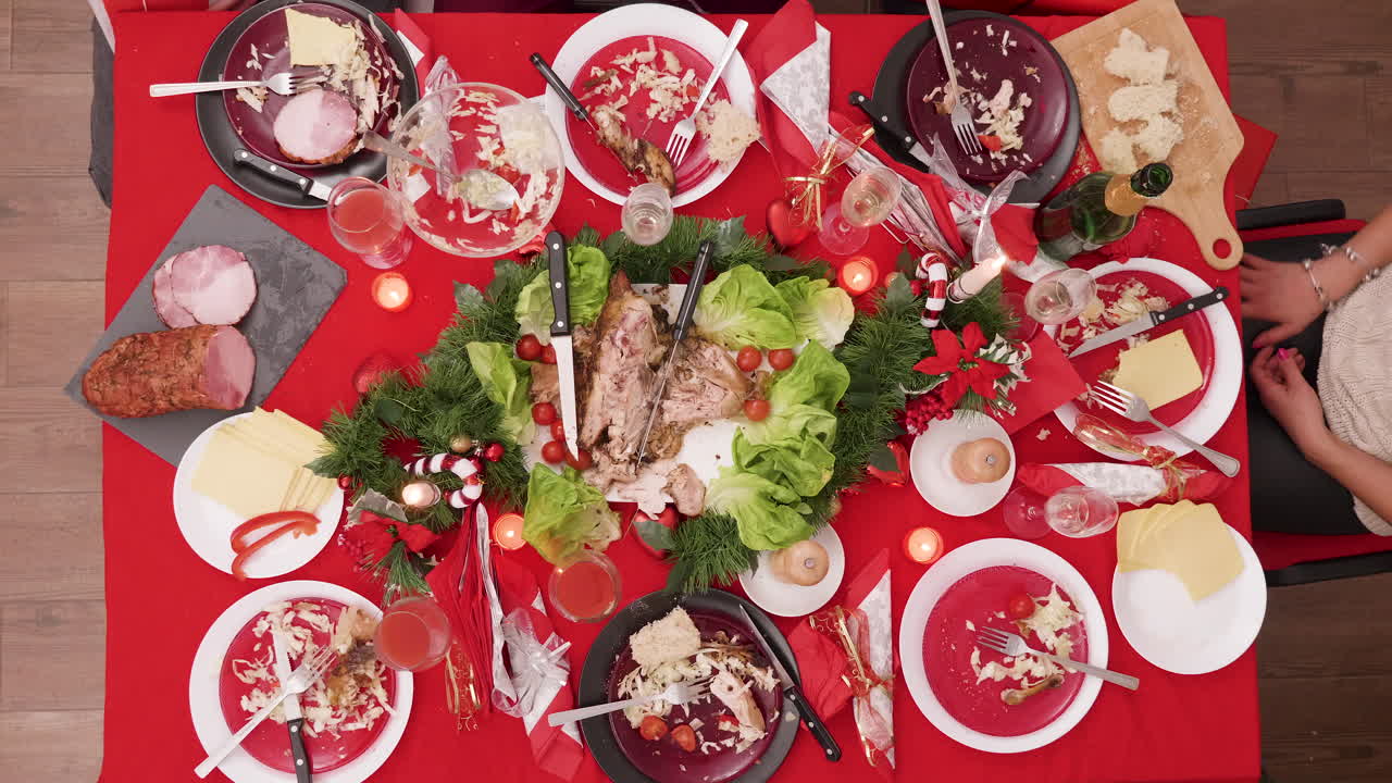 Overhead view of a finished Christmas dinner table with leftovers and empty plates