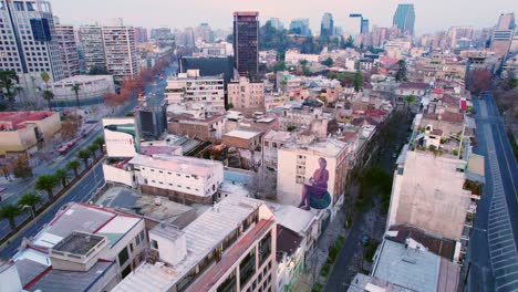 Dolly-in-aerial-view-of-Lastarria-neighborhood,-bohemian,-residential-and-touristic-area-in-early-morning-hours-under-vehicular-traffic-Santiago-Chile