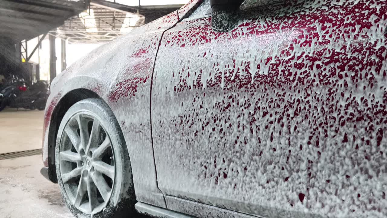 Auto rossa lavata con schiuma