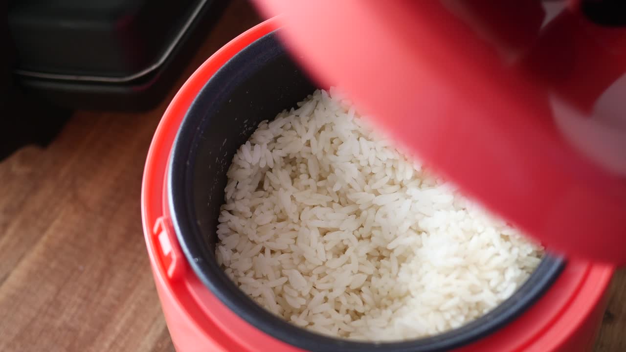 abriendo la tapa de una olla de arroz
