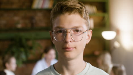 Primer-Plano-De-Un-Niño-Con-Gafas-Sonriendo-En-Clase