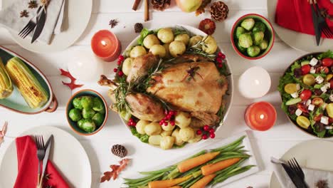video de bandeja con pavo asado, platos diversos y decoración de otoño en superficie blanca