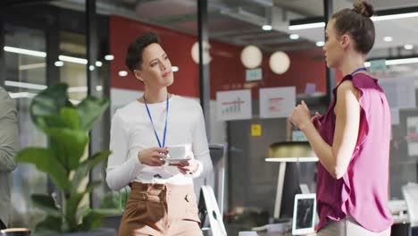 Happy-diverse-business-people-discussing-work-and-drinking-coffee-at-office