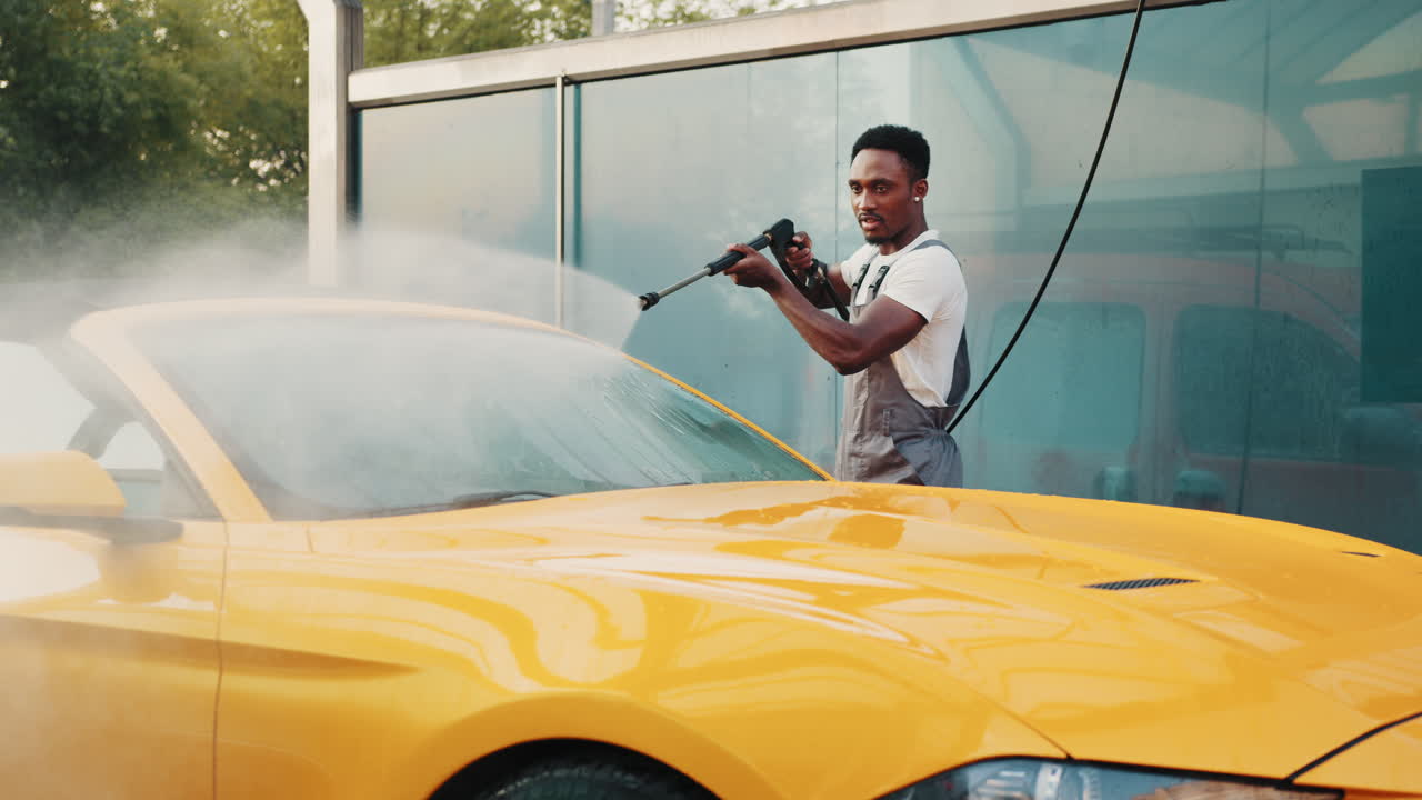 차 세탁장에서 노란색 컨버터블 차를 는 남자
