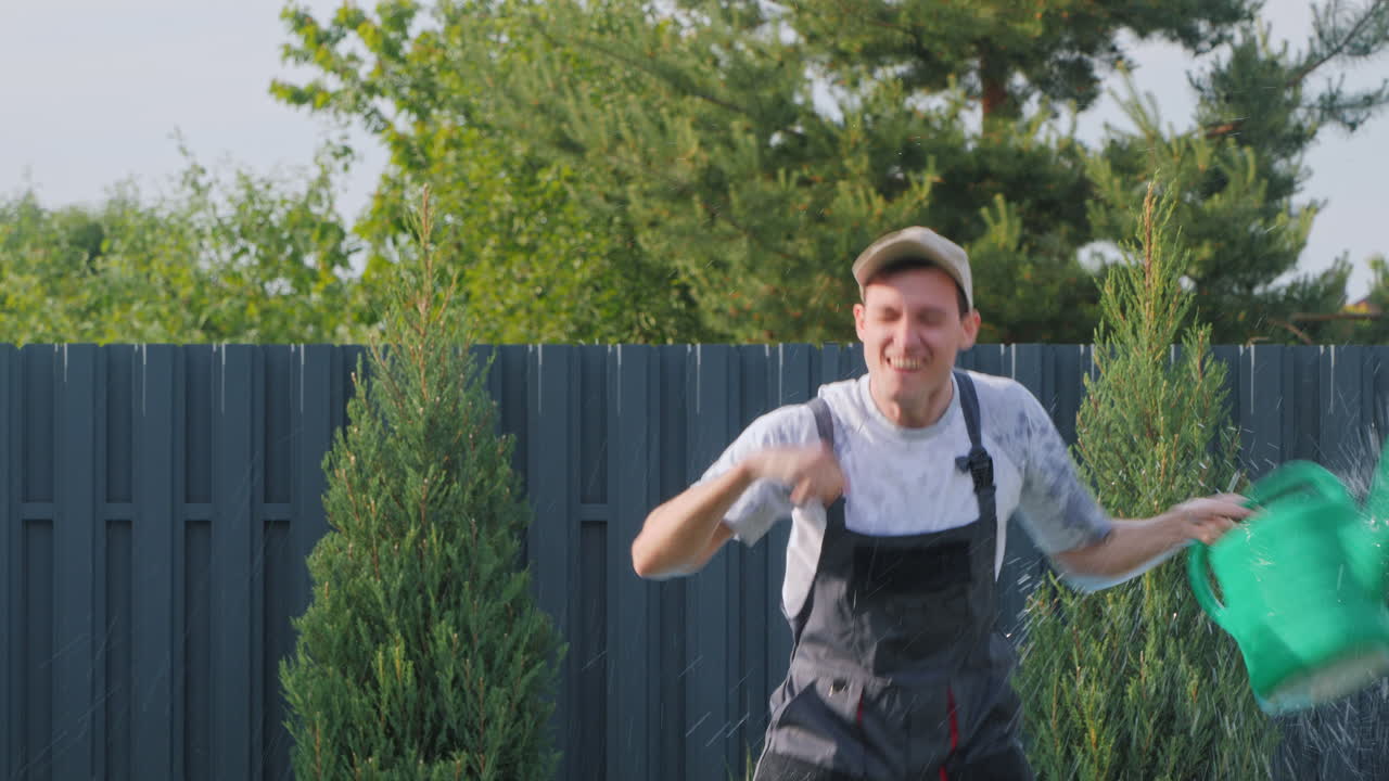 행복 한 정원사 가 식물 들 에게 물 을 주고 있다