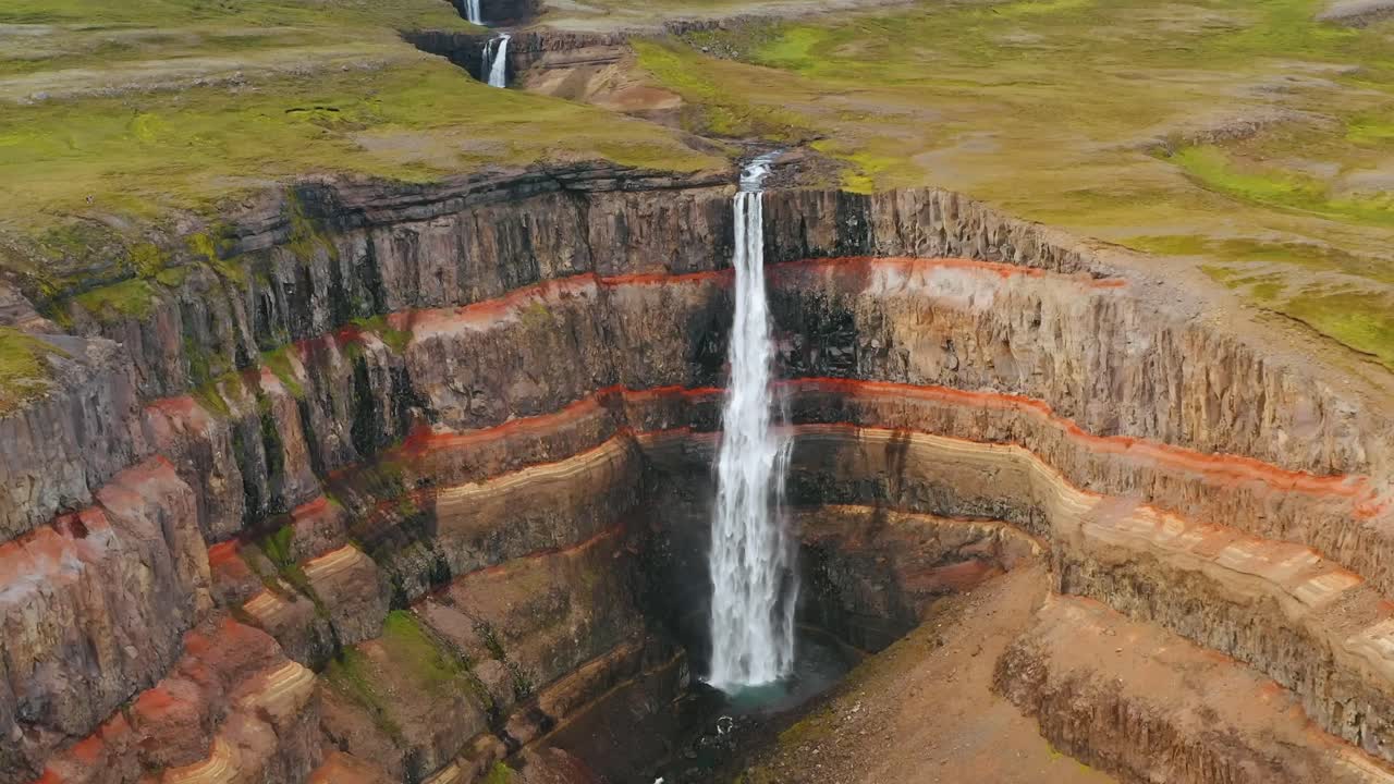 las imágenes aéreas de drones 4k capturan escenas cinematográficas de agua en cascada en un gran agujero circular dentro del parque de islandia.
